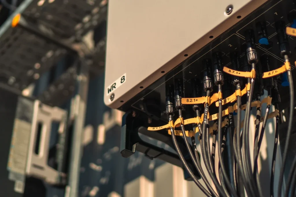 Kabel verbinden sich mit einem Verteilerkasten in einem technischen Raum, beschriftet mit "WR 8".