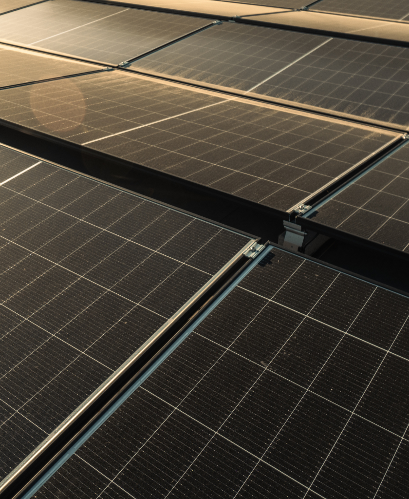 Solarmodule reflektieren Sonnenlicht auf einem Dach, angeordnet in parallelen Reihen.