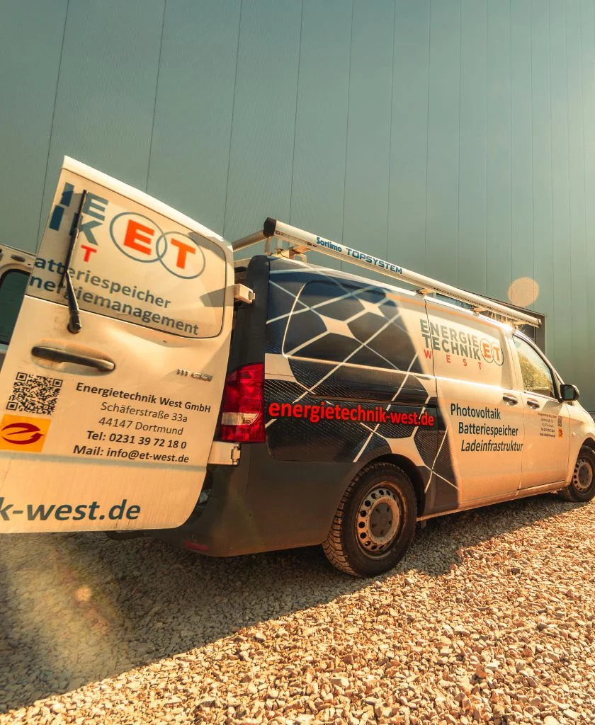 Transporter steht auf Schotterweg, Werbung für Energietechnik West GmbH, Photovoltaik, Ladesysteme.