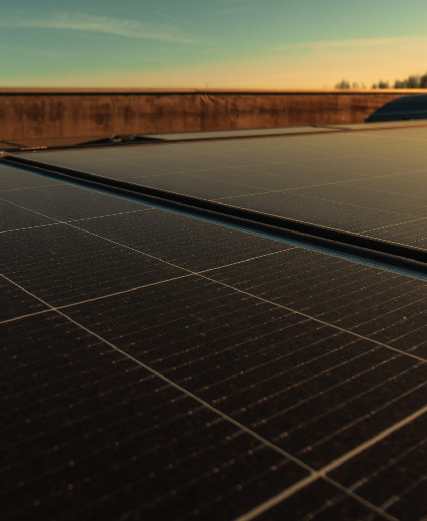Solarmodule sammeln Energie auf einem Dach bei Sonnenuntergang.