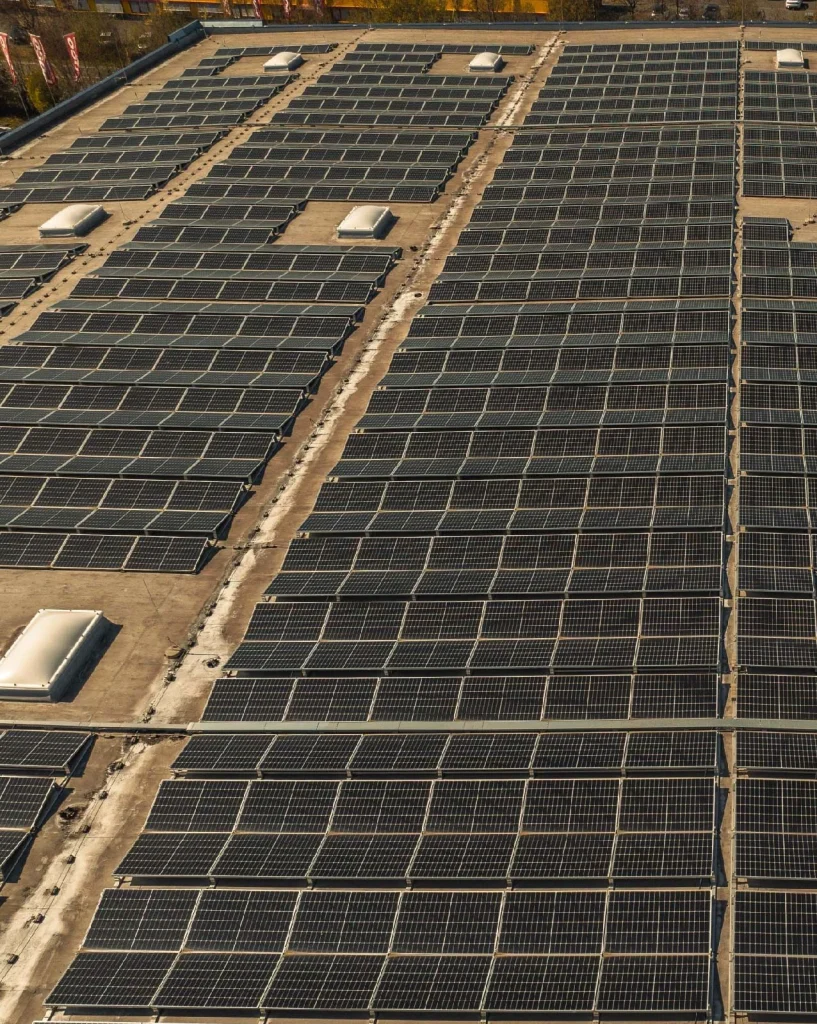 Solarmodule reflektieren Sonnenlicht, auf einem Dach montiert, in Reihen angeordnet.