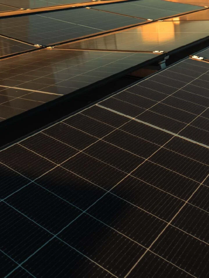 Solarmodule, reflektieren Sonnenlicht, auf einem Dach montiert. Links Schatten durch Lichtstrahlen.