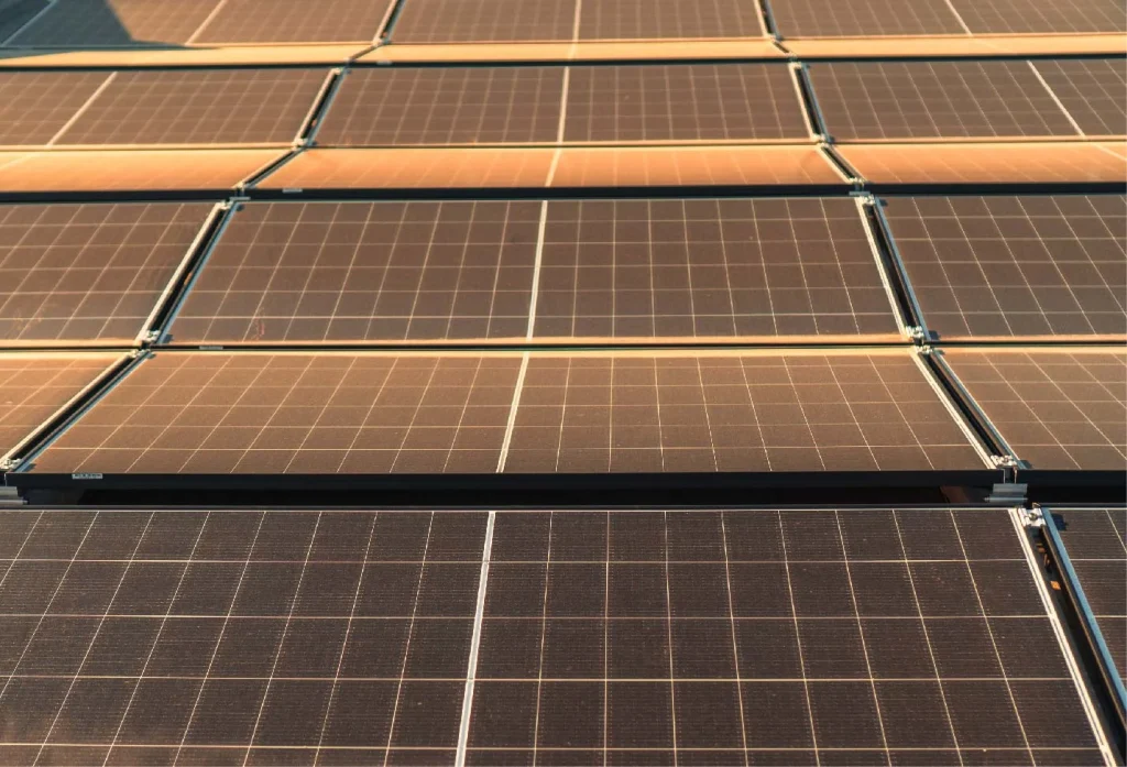 Solarmodule reflektieren Sonnenlicht, auf einem Dach montiert, in Reihen angeordnet.