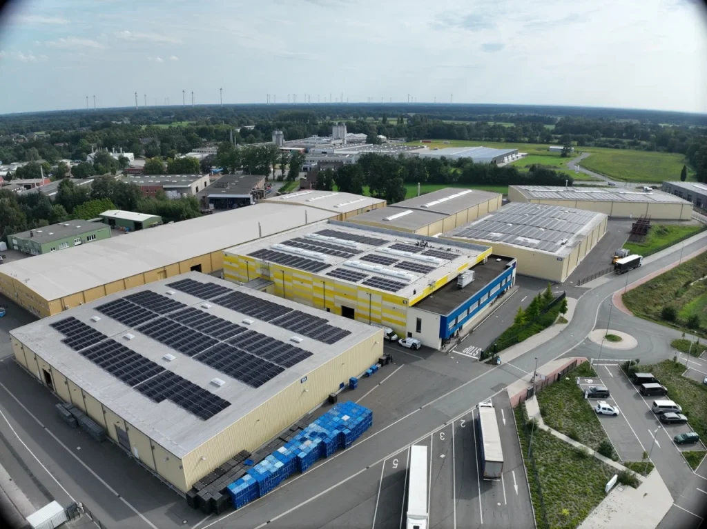 Dach des Gebäudes - Mit Solarpaneelen bedeckt - In einem Industriegebiet mit Bäumen.