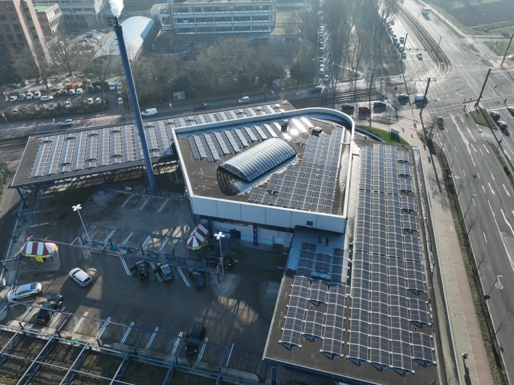 Solarmodule bedecken das Dach eines städtischen Gebäudes an einer Straßenkreuzung.