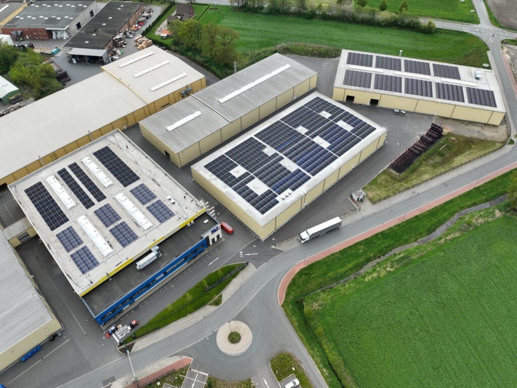 Dach des Gebäudes - Mit Solarpaneelen bedeckt - In einem Industriegebiet mit Bäumen.