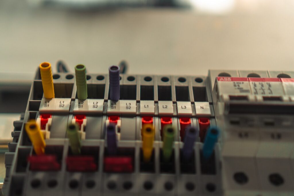 Mehrfarbige Kabel stecken in einer elektrischen Verteilerbox in industrieller Umgebung.