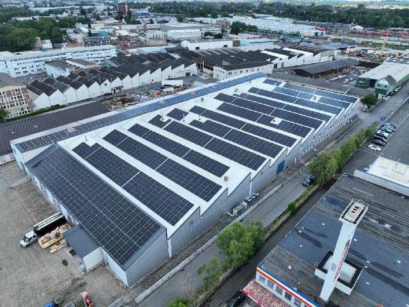Solarmodule bedecken Dach einer großen Lagerhalle in einem Industriegebiet.