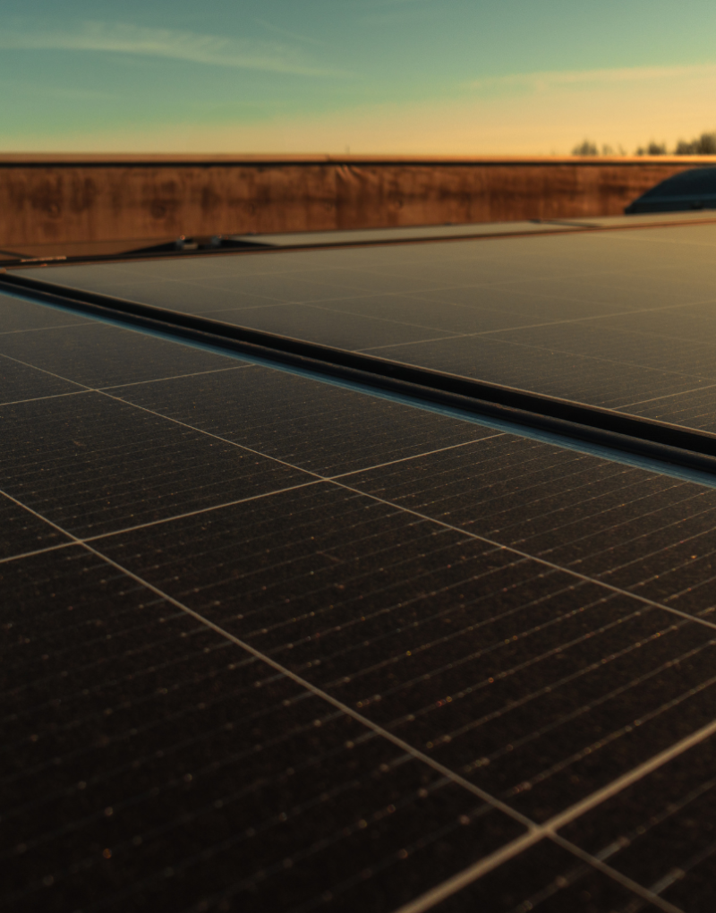 Solarmodule sammeln Energie auf einem Dach bei Sonnenuntergang.
